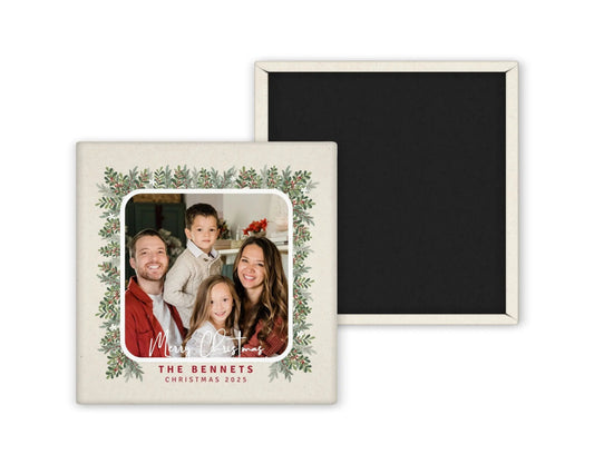 Personalized Merry Christmas photo magnet with family portrait, custom name, and holiday greenery border